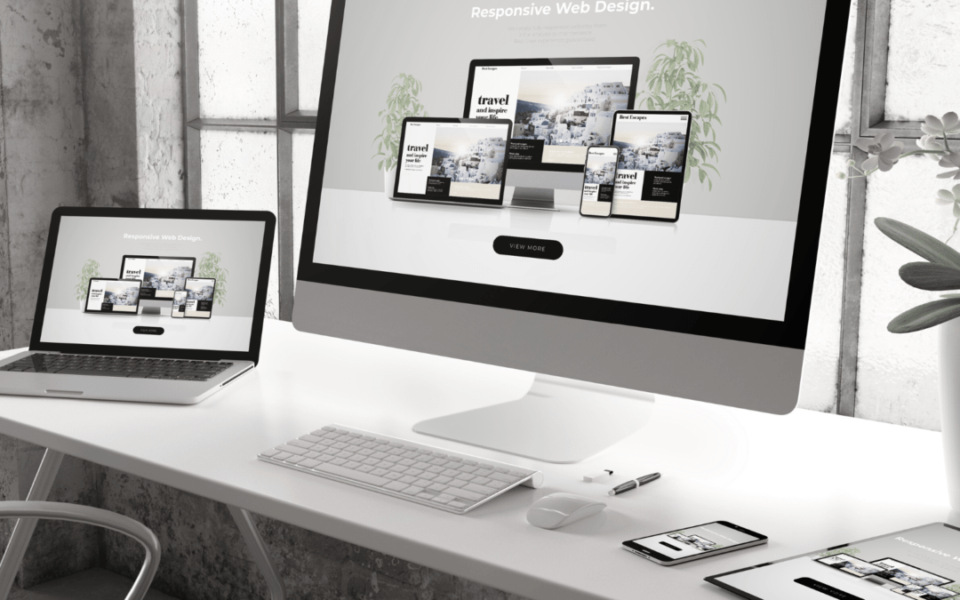 Ein moderner Arbeitsbereich mit einem großen Monitor und einem Laptop zeigt responsives Webdesign. Die Geräte präsentieren diverse Layouts in einem stilvollen, hellen Raum.