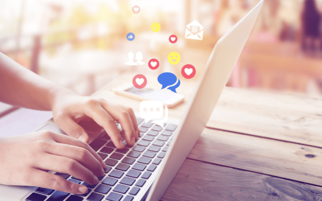 Eine Person tippt auf einer Laptop-Tastatur in einem Café, während verschiedene Symbol-Icons für soziale Medien schweben.