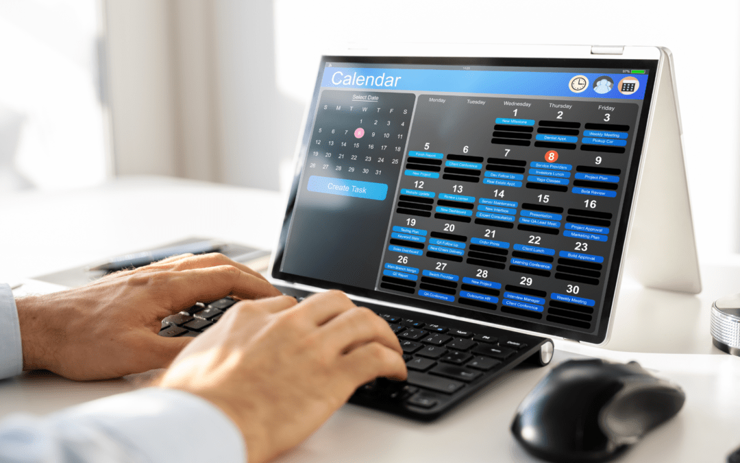 Ein Laptop mit Kalenderanwendung, die Termine und Aufgaben anzeigt; eine Hand tippt auf der Tastatur, während eine ruhige Arbeitsumgebung sichtbar ist.